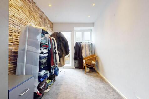 Bright, narrow bedroom with a feature textured ...