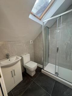 Modern tiled bathroom with a corner shower cubi...