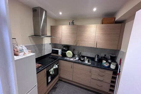 Modern galley kitchen with wood-effect cabinets...