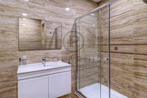 A modern bathroom with beige tiled walls features 