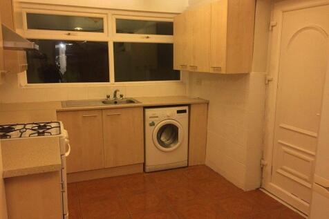 Well-equipped kitchen with light wood cabinets,...