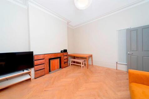 Spacious living room with wooden floors...
