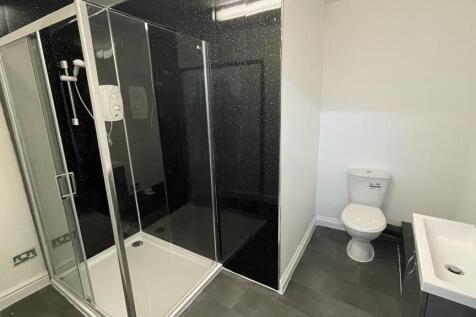 Modern bathroom with stylish black shower tilin...