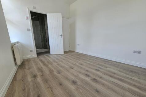 Bright, freshly painted bedroom with modern woo...