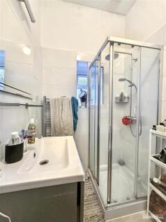 Bright modern shower with stylish white tiling...
