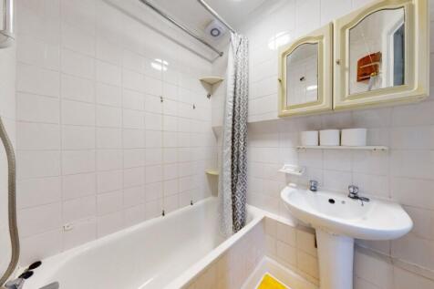 Bright bathroom suite with bath and storage...