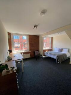Spacious, bright bedroom with exposed brick det...