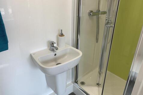 Modern shower suite with sleek white fixtures...