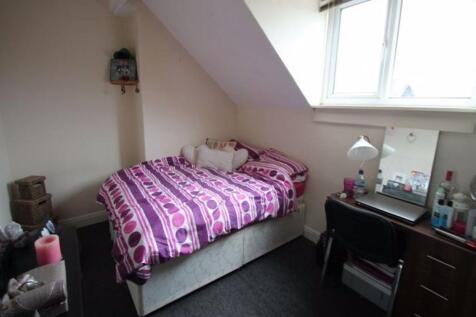 A cozy single bedroom with a sloped roof, featu...