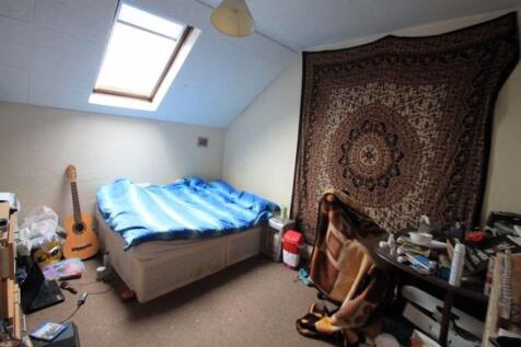 Bright and cozy bedroom featuring a comfortable...