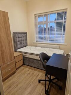 Bright bedroom with stylish desk and wood floor...