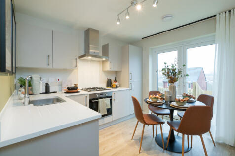 A modern kitchen with a white countertop and stainless steel appliances in the foreground is complem