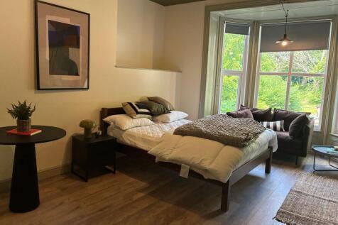 Bright bedroom with bay window and stylish deco...