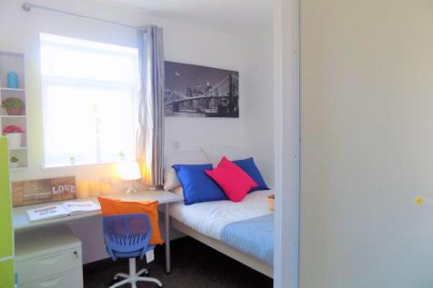 Bright, neatly furnished single bedroom with a ...
