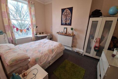 A cozy double bedroom featuring a large window ...