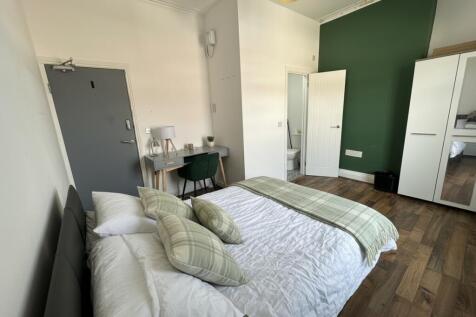 Bright bedroom with stylish desk and wood floor...