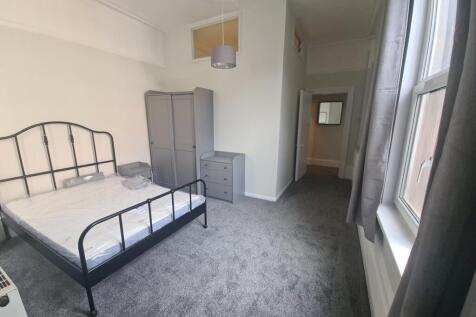 Bright double bedroom with large window and bed...