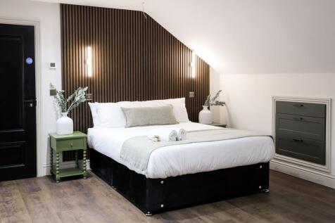 Stylish double room with modern wood feature wa...