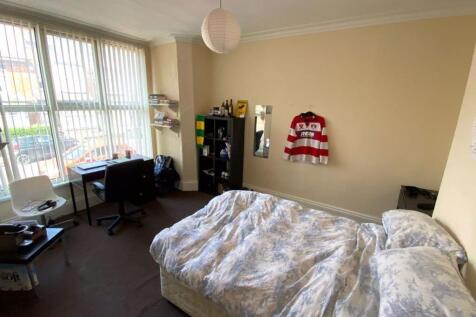 A spacious and well-lit bedroom featuring a lar...
