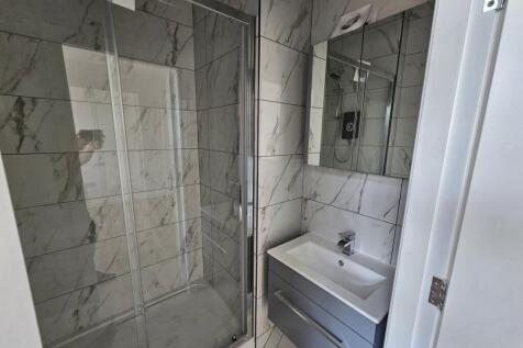 Modern bathroom with a large glass-enclosed sho...
