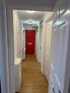 Bright, well-maintained hallway with warm wood-...