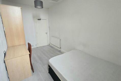 An image showing a small, tidy bathroom with a ...