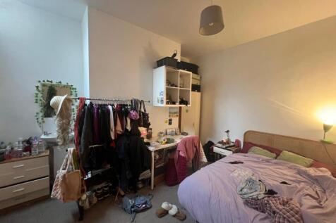 Cozy furnished bedroom with shelving and natura...