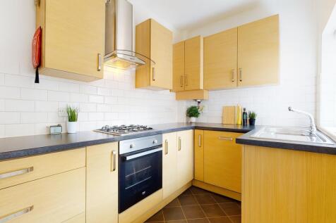 Bright, modern kitchen with light wood cabinetr...