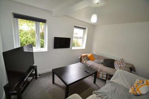 A bright, welcoming living room featuring two w...