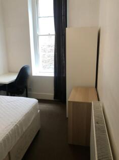 A tidy double bedroom with a desk and chair, fe...