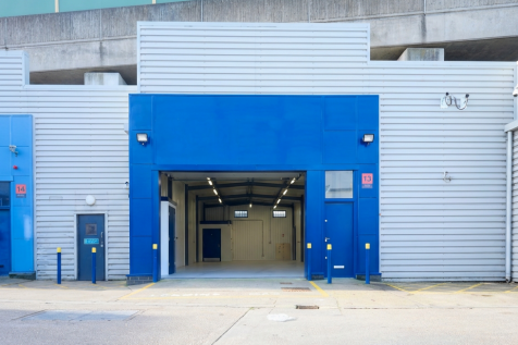 The front of an arch with an open electric roller shutter entrance big enough for vehicle access, and separate pedestrian door.