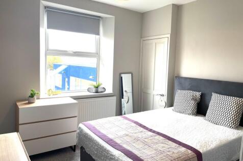 Bright and modern master bedroom featuring a la...