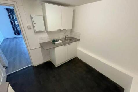 Compact kitchenette with fitted cabinets and si...