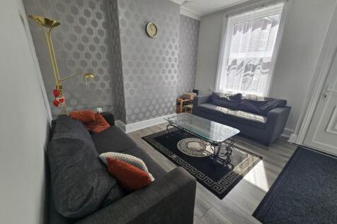 A spacious and well-lit living room featuring c...