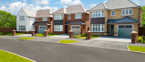 A row of modern detached houses with pitched roofs and garages, set on a quiet street with well-main