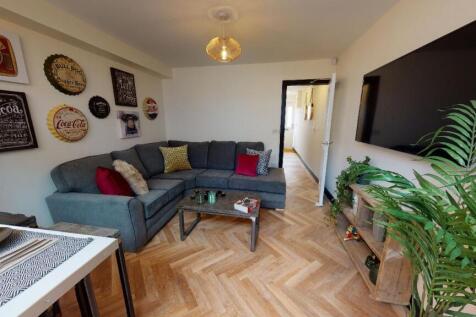 A spacious, well-lit living room featuring a la...