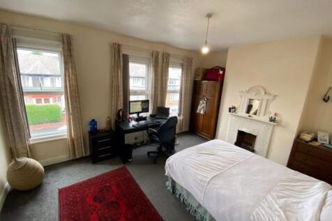 A spacious and bright bedroom featuring large w...