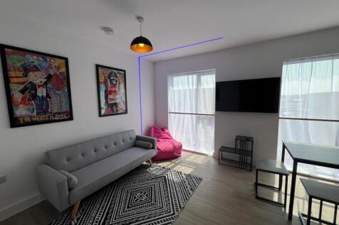 Bright, modern living room with a sleek grey so...