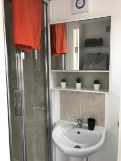 Bright, modern bathroom with a tiled shower cub...