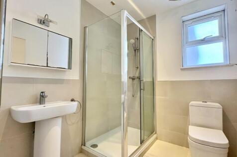 Bright, modern bathroom with glass shower cubic...