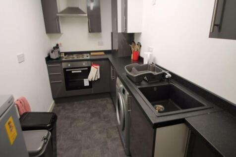 Modern kitchen area with sleek black countertop...