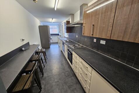 A modern kitchen featuring a long countertop wi...