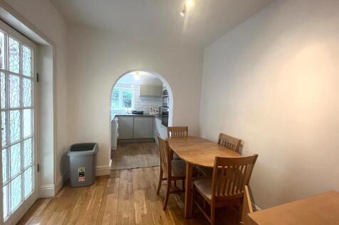Bright dining area opening through an arched do...