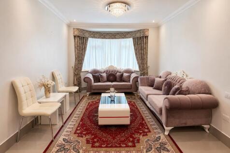 Elegant living room with plush sofas and bay wi...