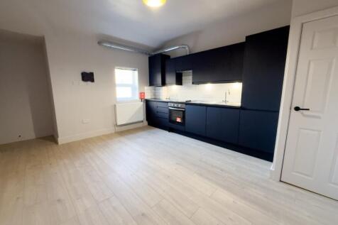 Modern open-plan kitchen with sleek dark cabine...
