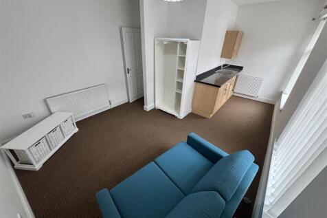 Bright living area with stylish blue sofa...