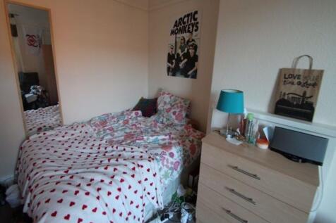 A cozy bedroom with a double bed covered in a p...