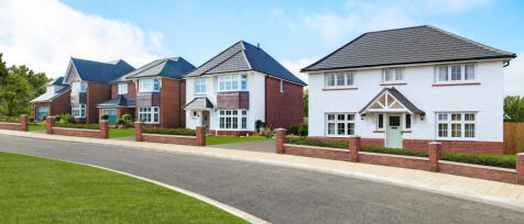 A row of modern detached houses with brick and white exteriors, front gardens, and paved pathways al