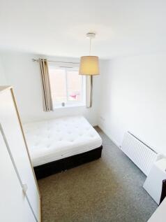 Bright, simply furnished bedroom with a comfort...