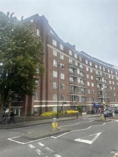 Red-brick apartment block on a broad city stree...